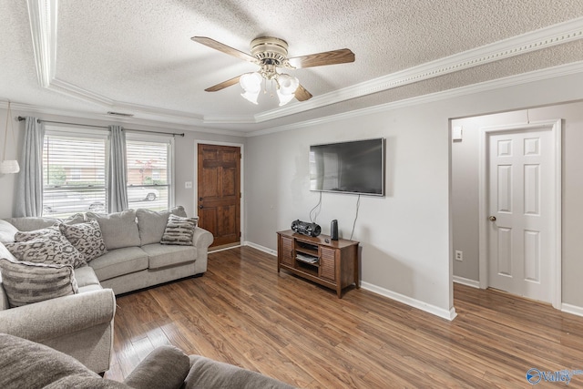 living room featuring crown molding, ceiling fan, a raised ceiling, and hardwood / wood-style floors