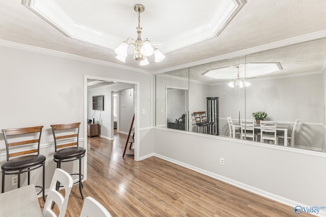 dining room featuring a notable chandelier, crown molding, and hardwood / wood-style floors