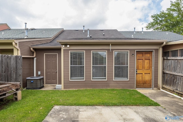 back of house with a yard and central AC unit
