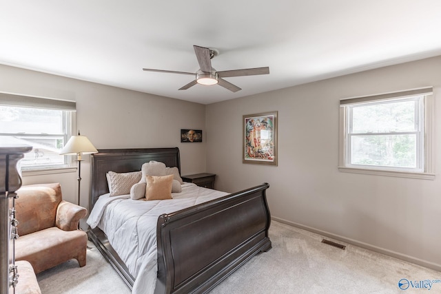 bedroom with visible vents, baseboards, ceiling fan, and light carpet