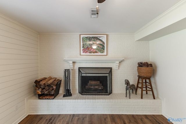 details with crown molding, wood finished floors, visible vents, and a fireplace