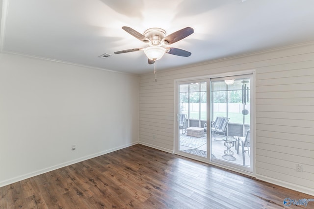 unfurnished room with baseboards, visible vents, ornamental molding, and wood finished floors