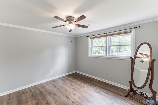 empty room with baseboards, crown molding, ceiling fan, and wood finished floors