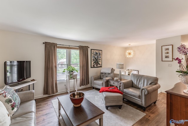 living area with baseboards and wood finished floors