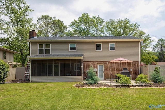 rear view of property featuring fence, a sunroom, a chimney, a patio, and a yard