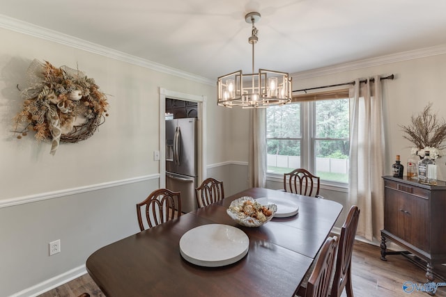 dining room featuring an inviting chandelier, crown molding, and wood finished floors