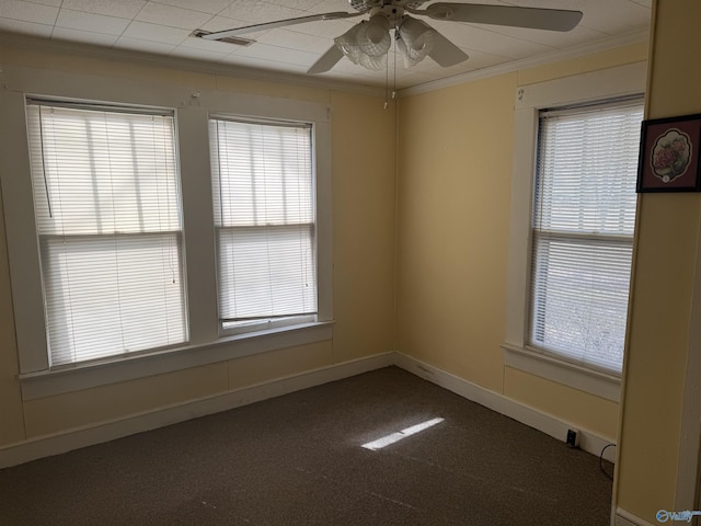 empty room featuring carpet flooring, a healthy amount of sunlight, crown molding, and baseboards