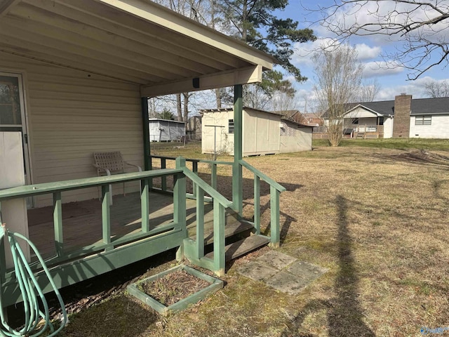 view of yard featuring an outbuilding, a shed, and a deck