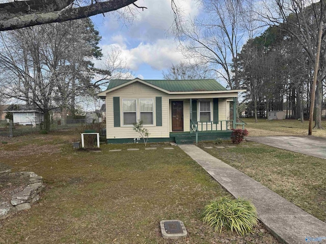 view of front of home with a porch, metal roof, and a front yard