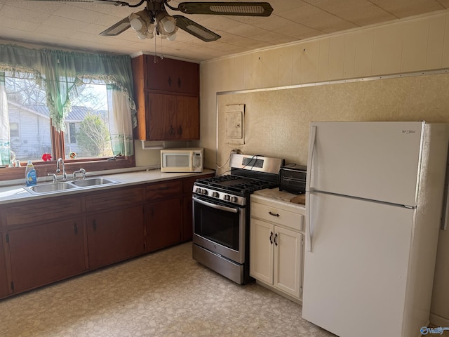 kitchen featuring a sink, white appliances, light floors, and light countertops