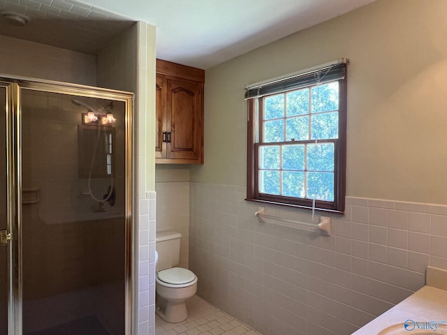 bathroom featuring toilet, tile patterned floors, walk in shower, and tile walls