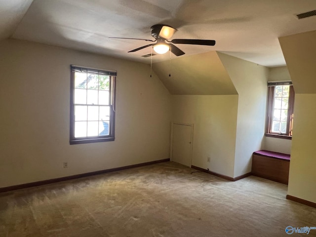 bonus room with lofted ceiling, ceiling fan, and plenty of natural light