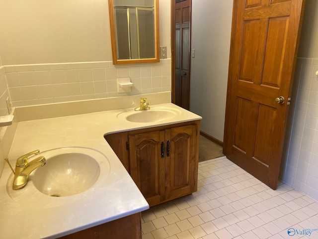 bathroom with vanity, tile walls, a shower with shower door, and tile patterned flooring