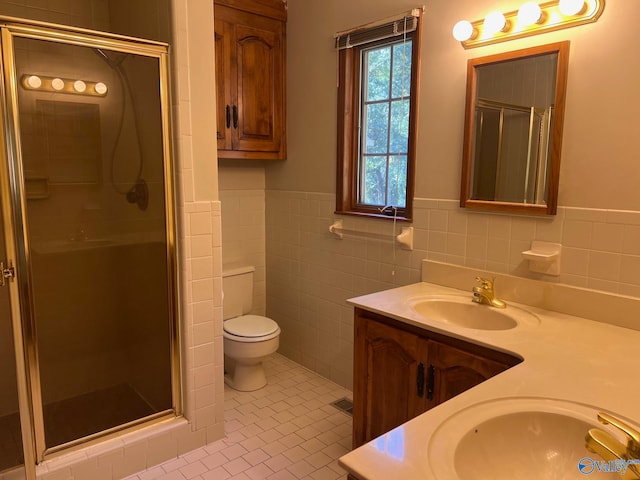 bathroom featuring tile walls, toilet, vanity, an enclosed shower, and tile patterned flooring