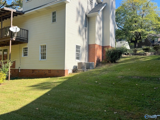 view of property exterior with central AC unit, a lawn, and a balcony