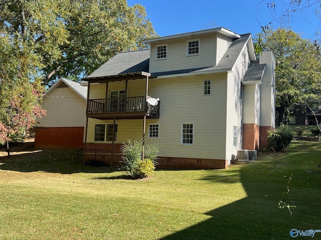 back of property featuring central air condition unit, a lawn, and a balcony