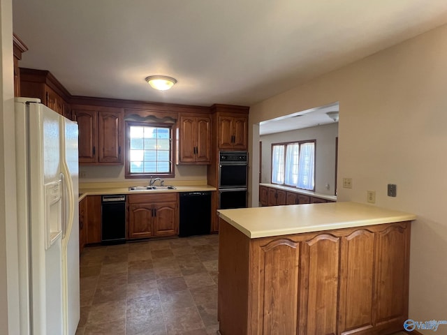 kitchen featuring kitchen peninsula, a healthy amount of sunlight, black appliances, and sink