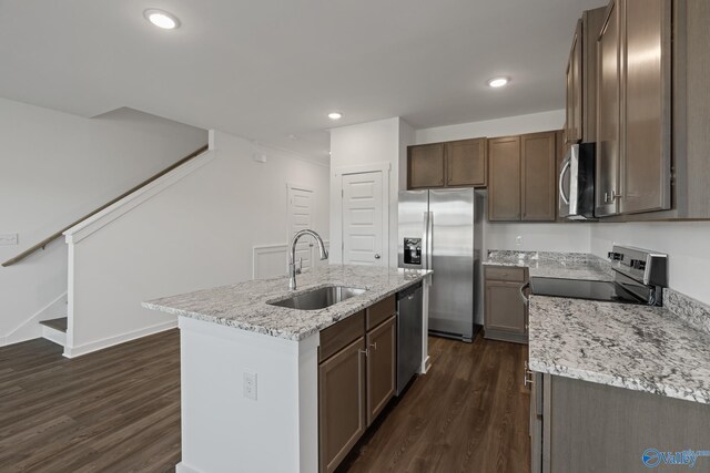 kitchen featuring a kitchen island with sink, stainless steel appliances, dark wood-type flooring, and a sink