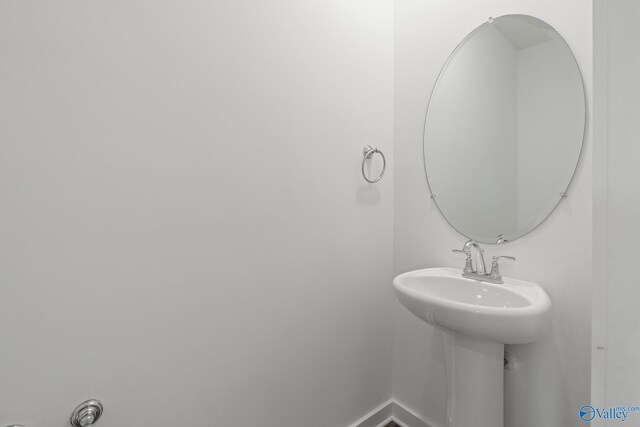 bathroom featuring baseboards and a sink