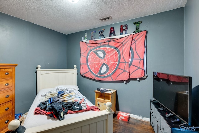 bedroom featuring dark hardwood / wood-style flooring and a textured ceiling