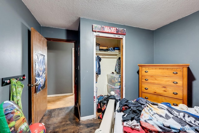 bedroom featuring a closet, dark hardwood / wood-style floors, and a textured ceiling