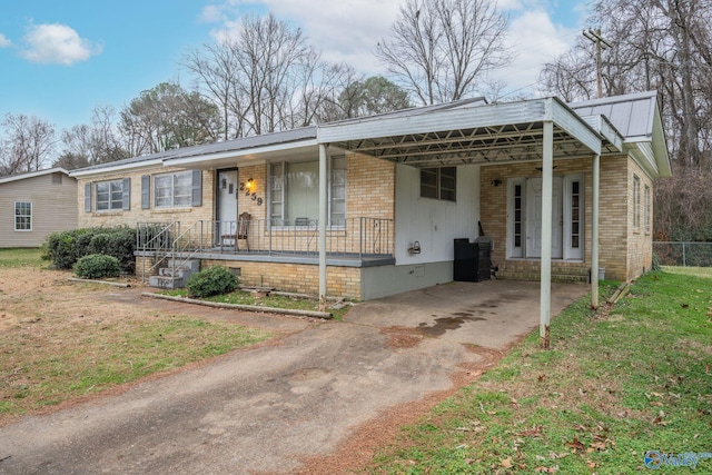 ranch-style home featuring a carport, a porch, and a front yard