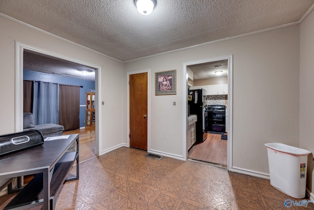 interior space with ornamental molding and a textured ceiling