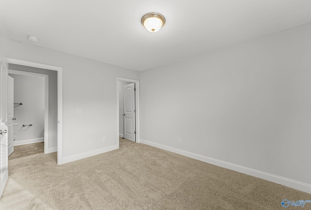 unfurnished bedroom with light colored carpet and baseboards