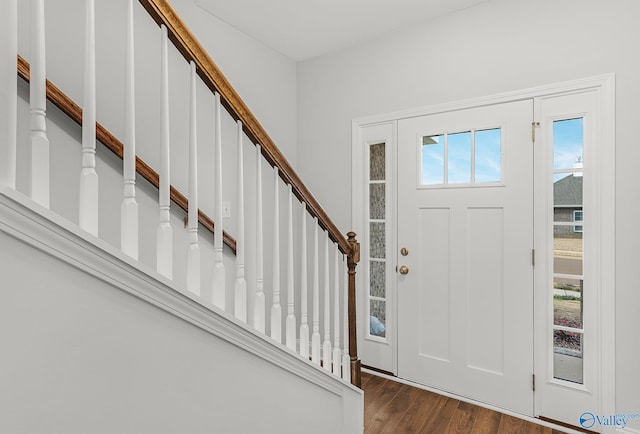 entryway featuring dark wood finished floors, plenty of natural light, and stairs