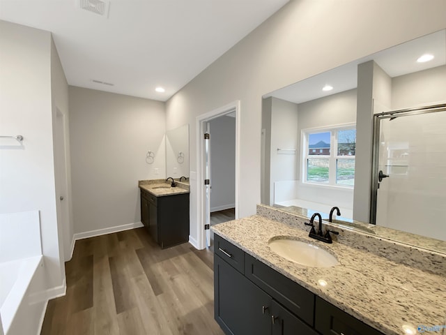 bathroom featuring wood-type flooring, independent shower and bath, and vanity