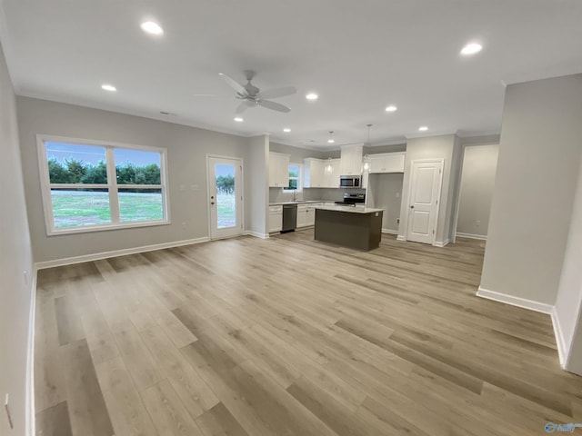 kitchen with white cabinetry, stainless steel appliances, light hardwood / wood-style floors, a kitchen island, and decorative light fixtures