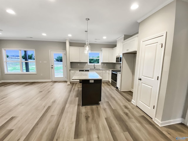 kitchen featuring a center island, hanging light fixtures, light wood-type flooring, stainless steel appliances, and white cabinets