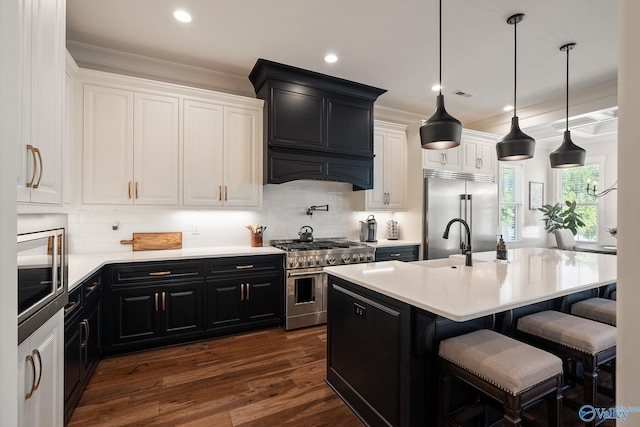 kitchen featuring white cabinetry, an island with sink, a breakfast bar area, and built in appliances