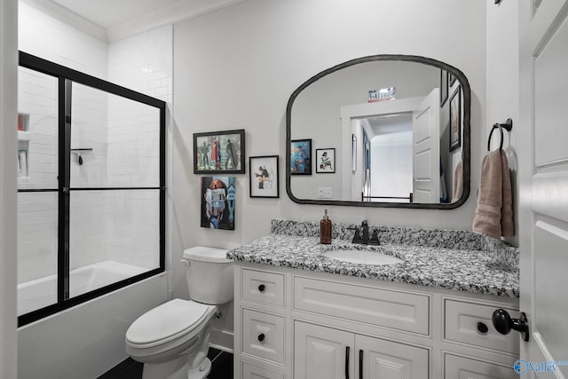 full bathroom with enclosed tub / shower combo, vanity, and toilet