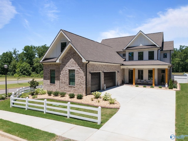 view of front of home with a garage, covered porch, and a front yard