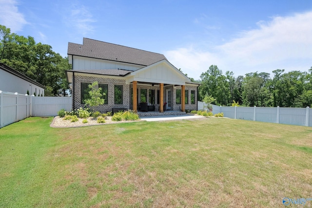 rear view of house featuring a yard and a patio area