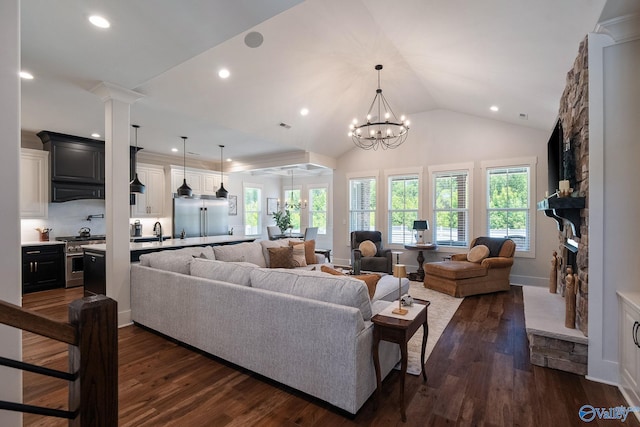 living room featuring a healthy amount of sunlight, lofted ceiling, dark hardwood / wood-style floors, and a fireplace