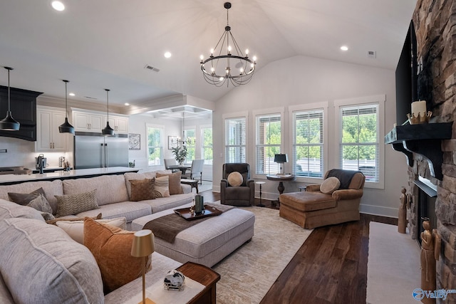 living room with hardwood / wood-style floors, a notable chandelier, a fireplace, and a healthy amount of sunlight