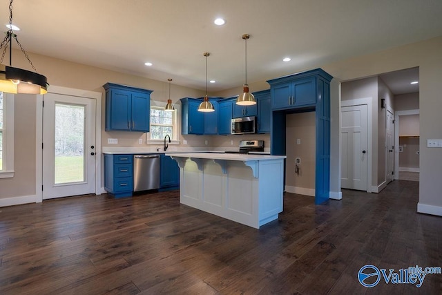 kitchen with light countertops, dark wood-style floors, stainless steel appliances, blue cabinets, and a sink