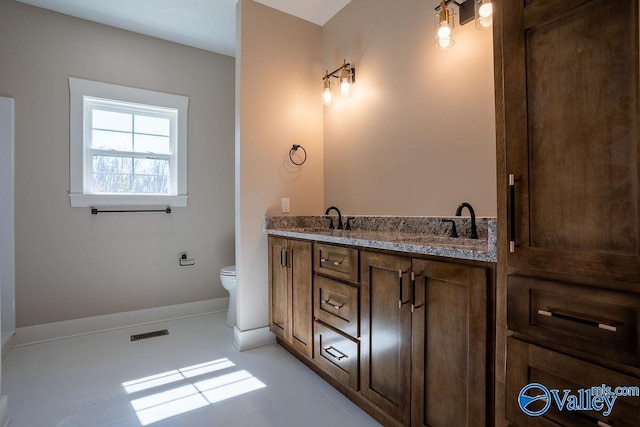 full bathroom featuring double vanity, toilet, visible vents, and a sink