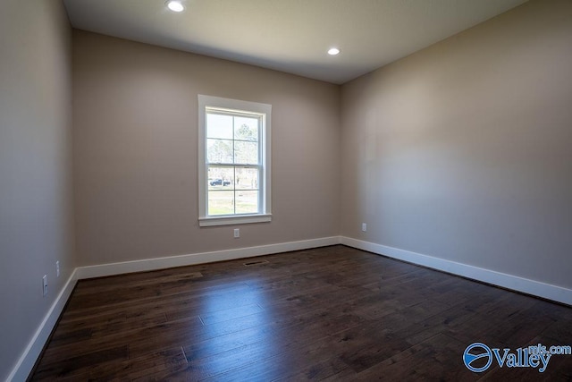 spare room with dark wood finished floors, recessed lighting, and baseboards