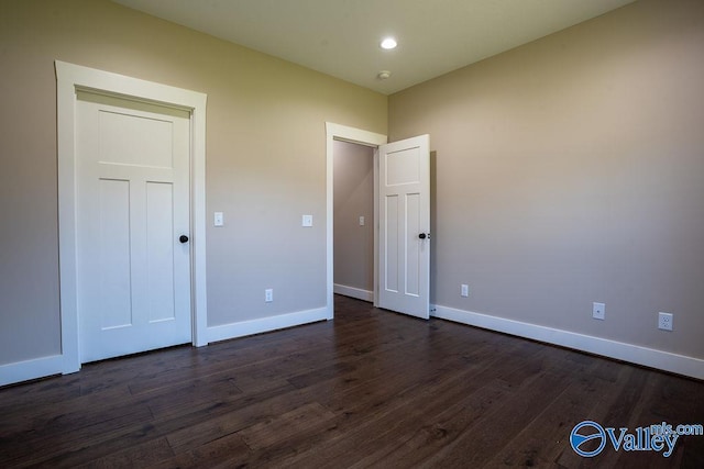 unfurnished bedroom with recessed lighting, dark wood-style floors, and baseboards