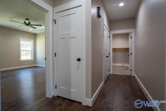 corridor featuring dark wood-type flooring, recessed lighting, and baseboards