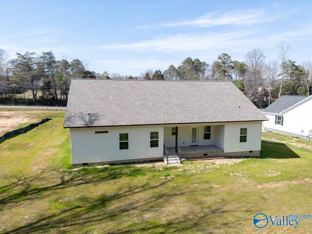 back of property with a lawn, roof with shingles, and crawl space