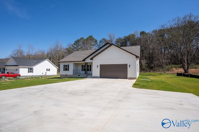 view of front of house with crawl space, driveway, an attached garage, and a front lawn
