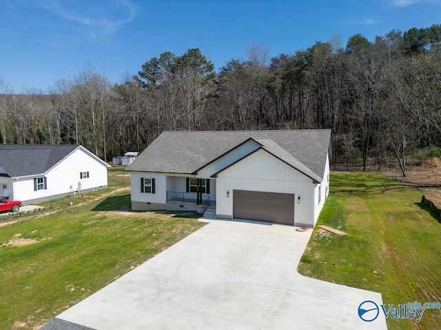 view of front of house with a garage, driveway, a front yard, and a shingled roof