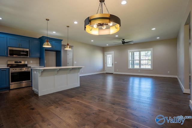 kitchen featuring blue cabinetry, light countertops, appliances with stainless steel finishes, dark wood-style floors, and a ceiling fan
