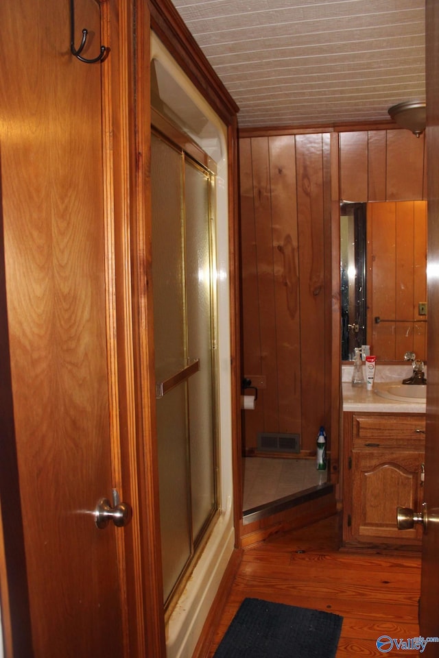 bathroom with a stall shower, wood finished floors, and vanity