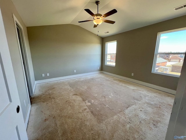 spare room with lofted ceiling, visible vents, ceiling fan, and baseboards