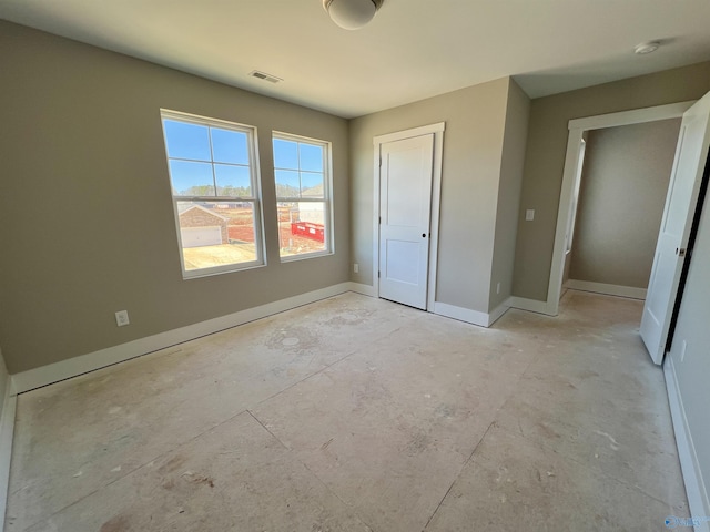 unfurnished bedroom with unfinished concrete floors, visible vents, and baseboards